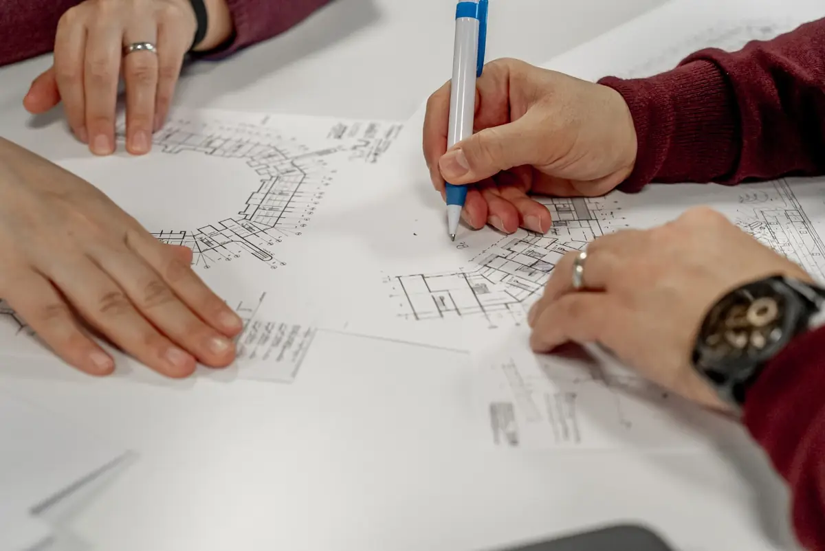 Ingeniør og bygherre gennemgår konstruktionstegninger sammen